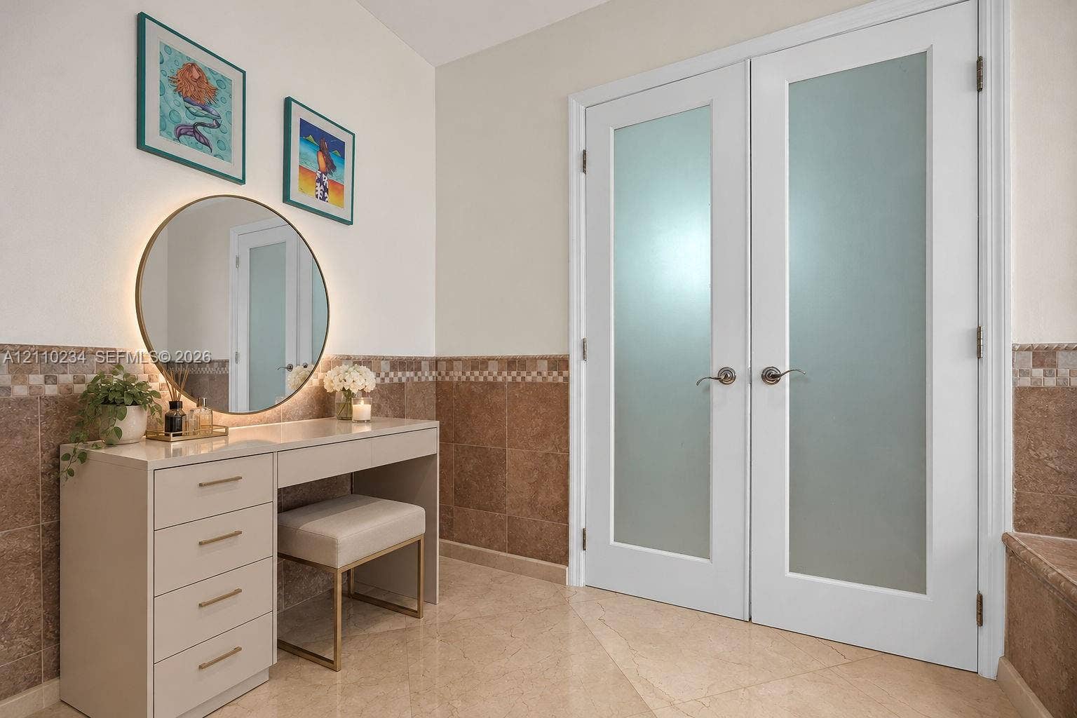 Built-in vanity featuring stone tile wainscoting and polished stone flooring, complemented by double doors with frosted glass panels