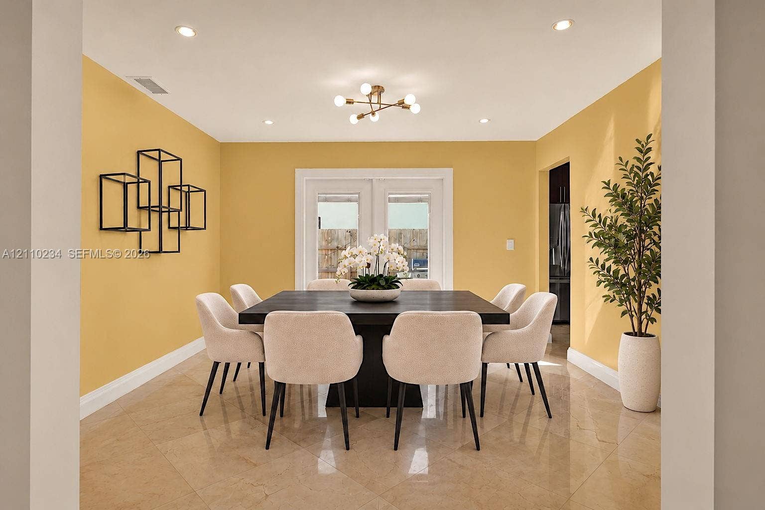 Dining area featuring polished stone-finish flooring, recessed lighting, a modern multi-arm chandelier, and glass-paneled double doors