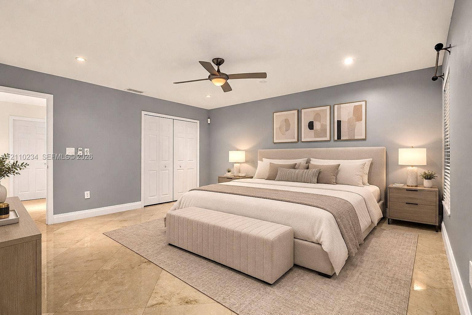 Spacious room featuring polished stone flooring, recessed lighting, a multi-blade ceiling fan, and double-door closet storage