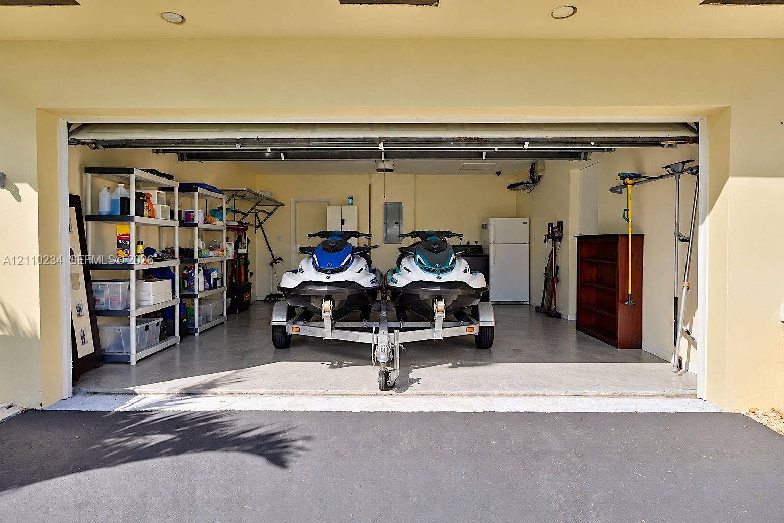 Two-car garage featuring recessed lighting, a finished concrete floor, and an automatic roll-up door