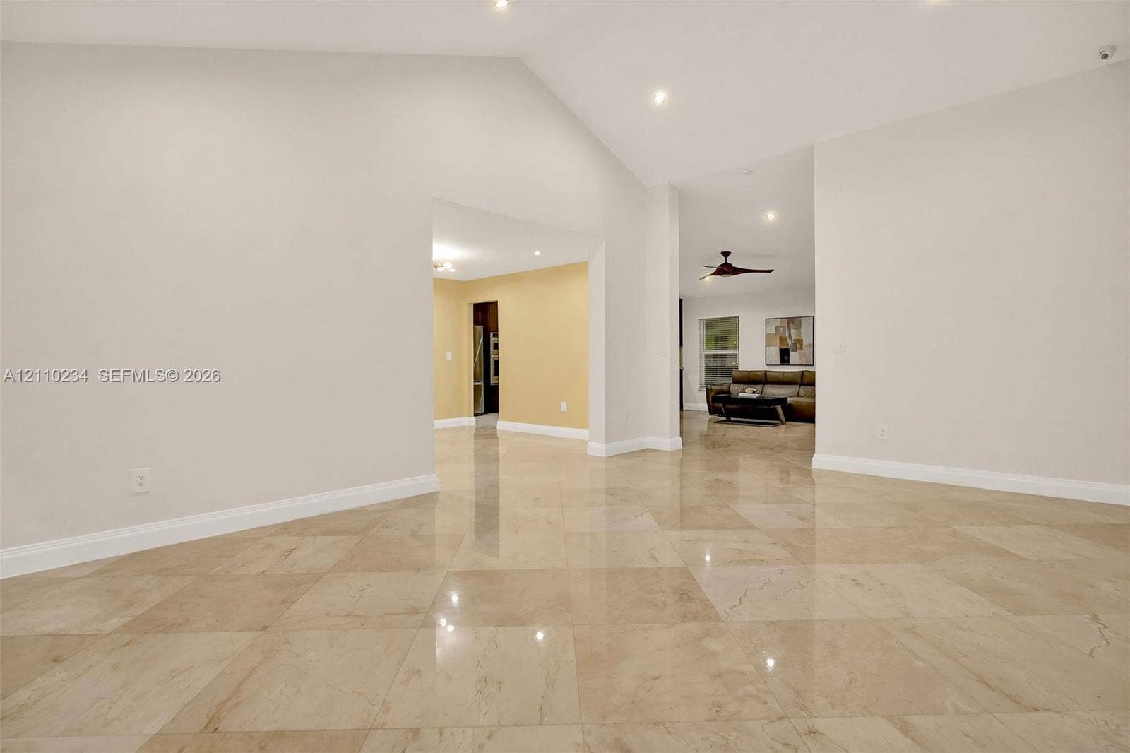 Vaulted ceilings featuring recessed lighting and polished stone-finish tile flooring