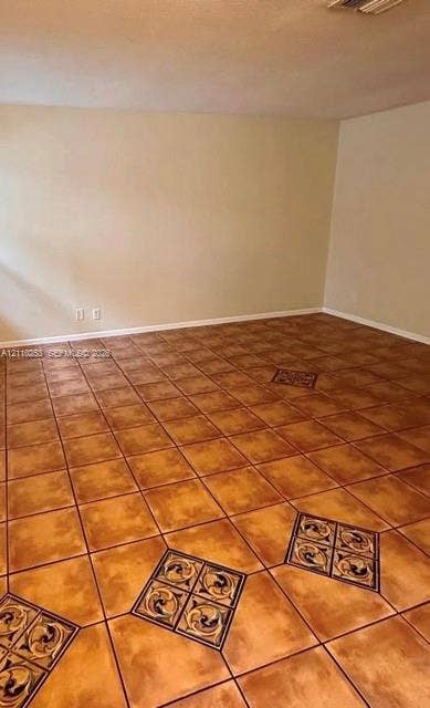 Interior room featuring large-format ceramic floor tiles with decorative inlaid tile medallions