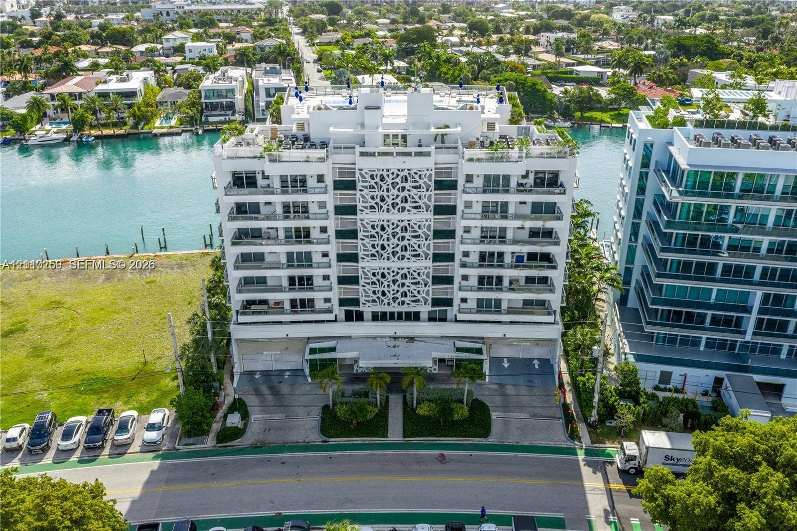 Mid-rise waterfront building featuring a decorative geometric facade, private balconies, and a rooftop terrace