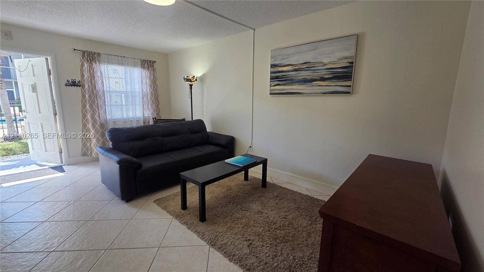 415 NE 2nd Street, #106, Hallandale Beach, Hallandale Beach, FL 33009 Neutral-toned interior featuring ceramic tile flooring, a multi-pane window, and a single-panel entry door