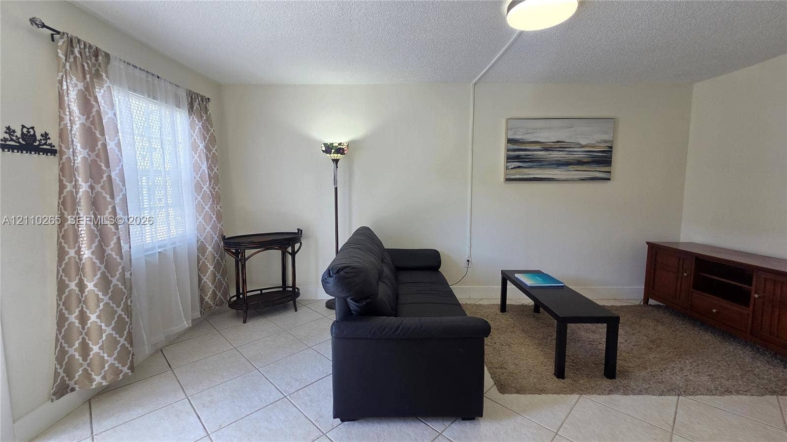 415 NE 2nd Street, #106, Hallandale Beach, Hallandale Beach, FL 33009 Room featuring neutral wall tones, large-format tile flooring, and a flush-mount ceiling light fixture