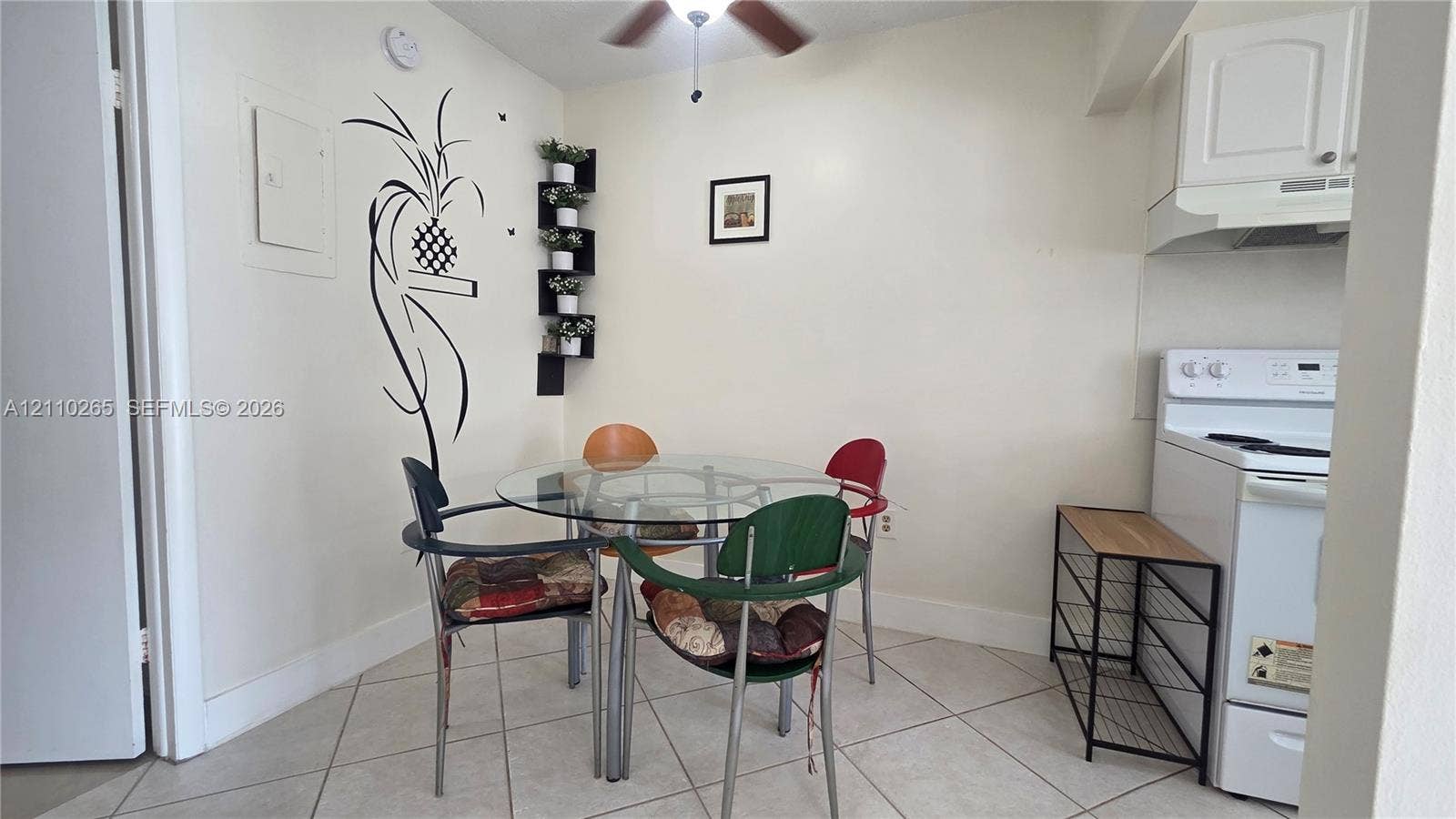 415 NE 2nd Street, #106, Hallandale Beach, Hallandale Beach, FL 33009 Ceramic tile flooring, ceiling fan with integrated lighting, and white cabinetry featuring a built-in range hood