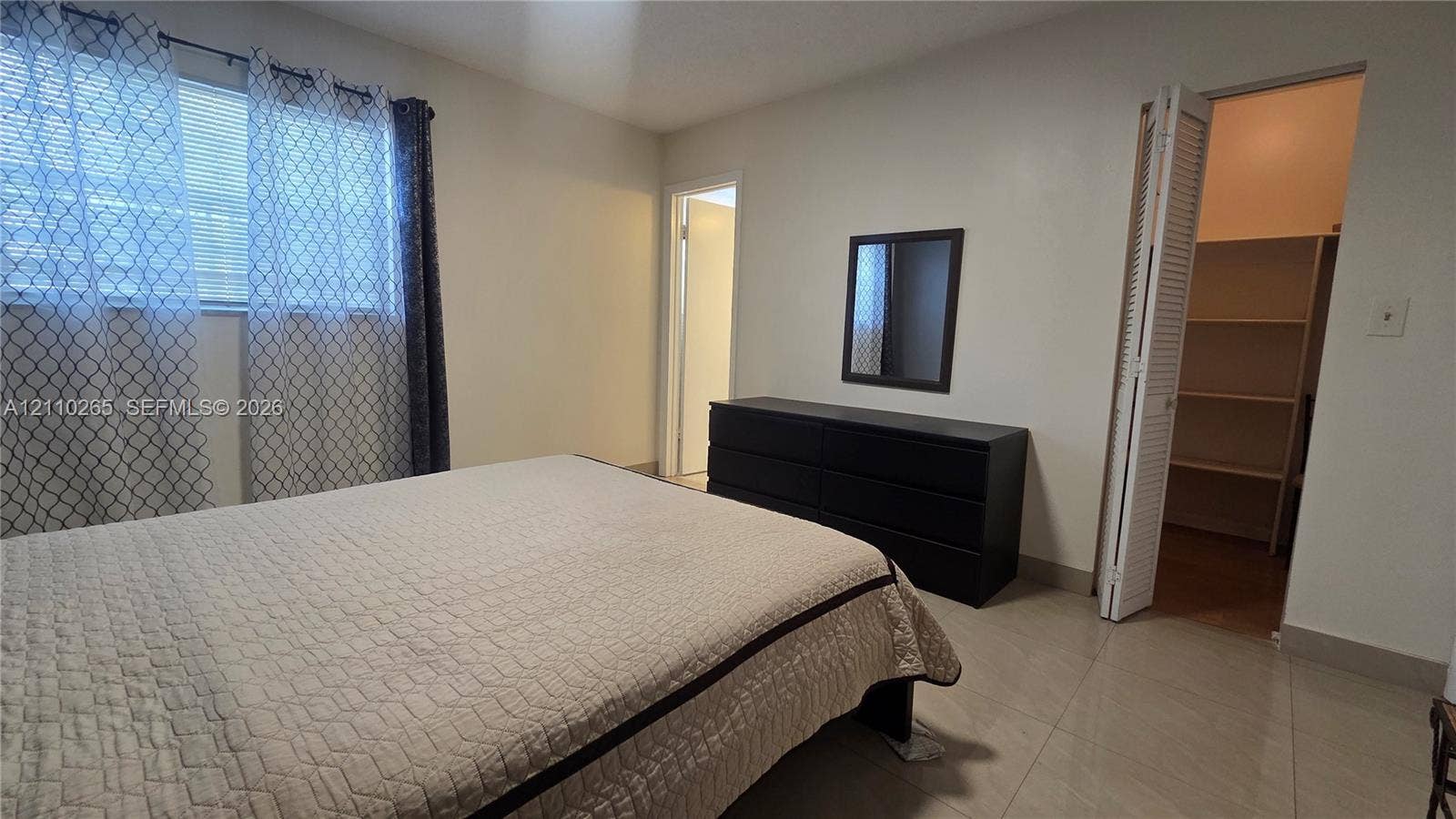 415 NE 2nd Street, #106, Hallandale Beach, Hallandale Beach, FL 33009 Neutral wall tones, horizontal window blinds, large-format tile flooring, and walk-in closet featuring built-in shelving