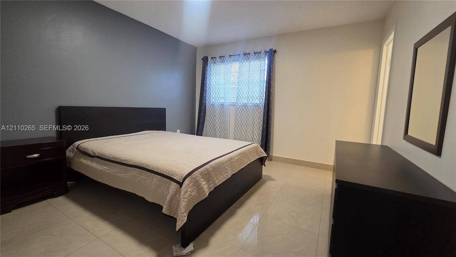 415 NE 2nd Street, #106, Hallandale Beach, Hallandale Beach, FL 33009 Interior space featuring light-toned tile flooring, neutral wall paint, and a dark-toned accent wall