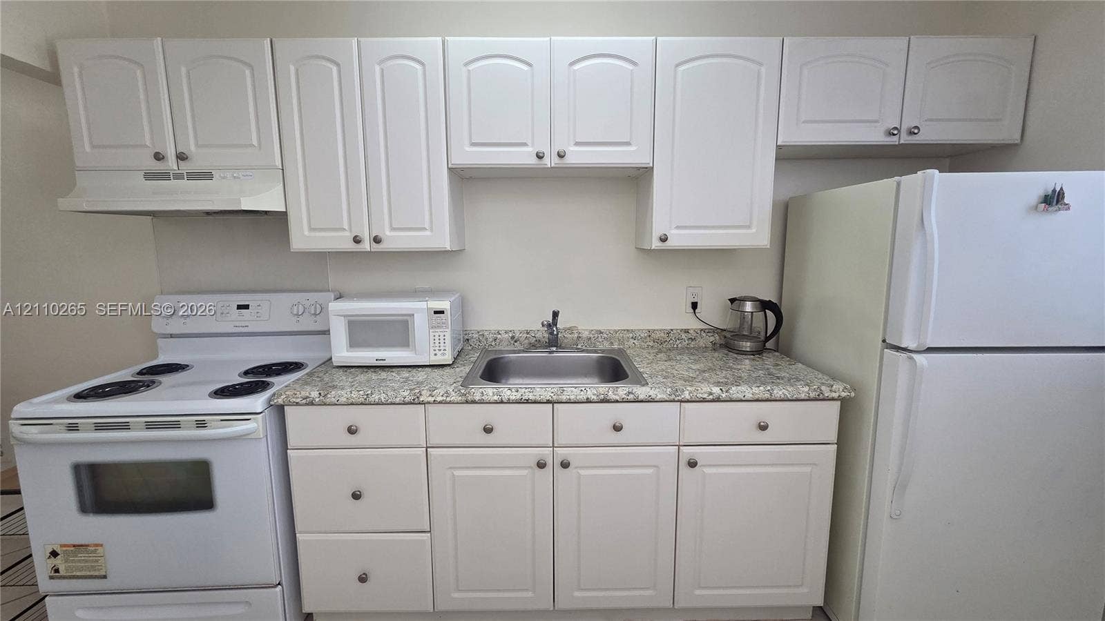415 NE 2nd Street, #106, Hallandale Beach, Hallandale Beach, FL 33009 Kitchen area featuring white shaker-style cabinetry, stone-finish countertops, stainless steel sink with a chrome faucet, and white electric range