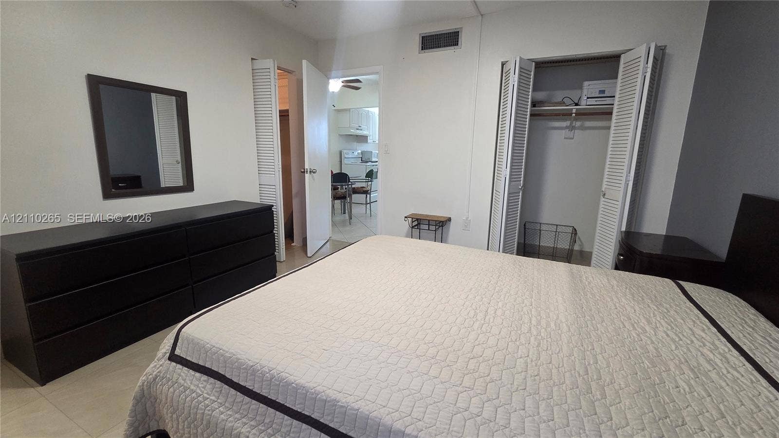 415 NE 2nd Street, #106, Hallandale Beach, Hallandale Beach, FL 33009 Bedroom featuring tile flooring, neutral wall tones, and a built-in closet with louvered doors