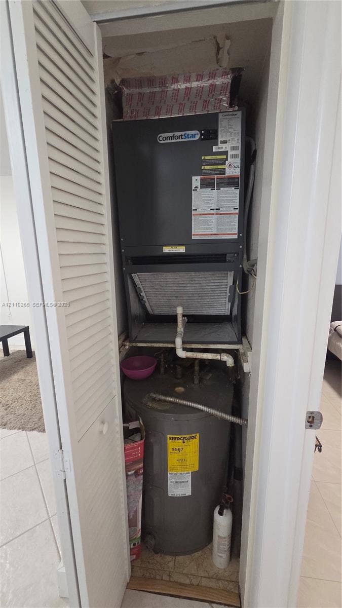 415 NE 2nd Street, #106, Hallandale Beach, Hallandale Beach, FL 33009 Utility closet housing a ComfortStar air handler and an upright water heater behind louvered bi-fold doors