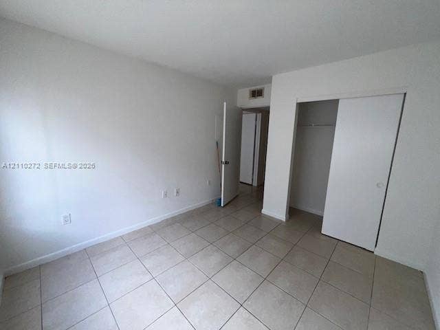 Room featuring neutral wall finishes, tile flooring, and a sliding door closet