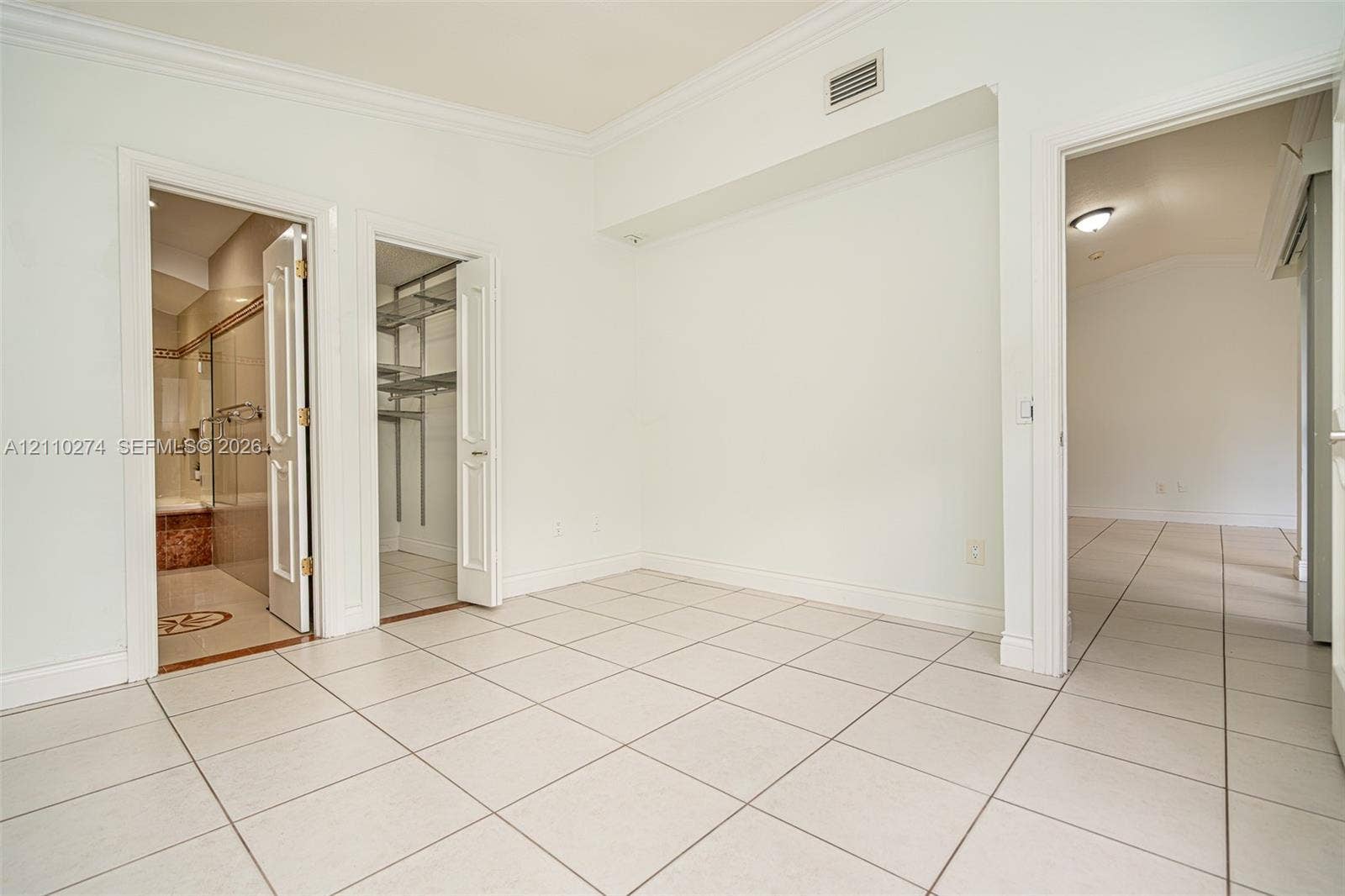 14955 SW 49th Lane, #5E, Miami, FL 33185 Neutral-toned ceramic tile flooring, solid-core interior doors, walk-in closet with built-in metal shelving, and crown molding