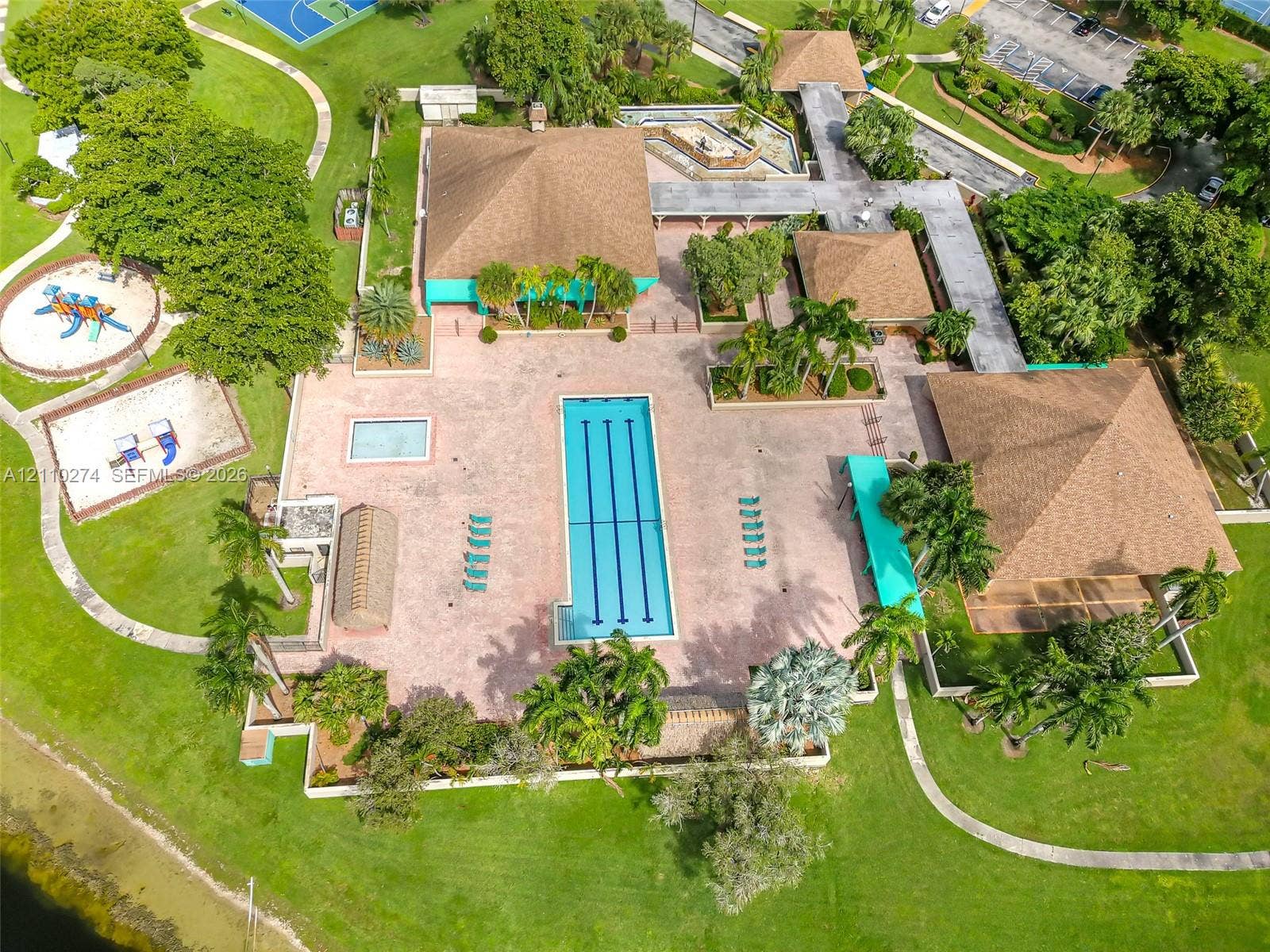 14955 SW 49th Lane, #5E, Miami, FL 33185 Aerial perspective of a community facility featuring a lap pool, secondary wading pool, paved sundeck, covered walkways, and manicured grounds