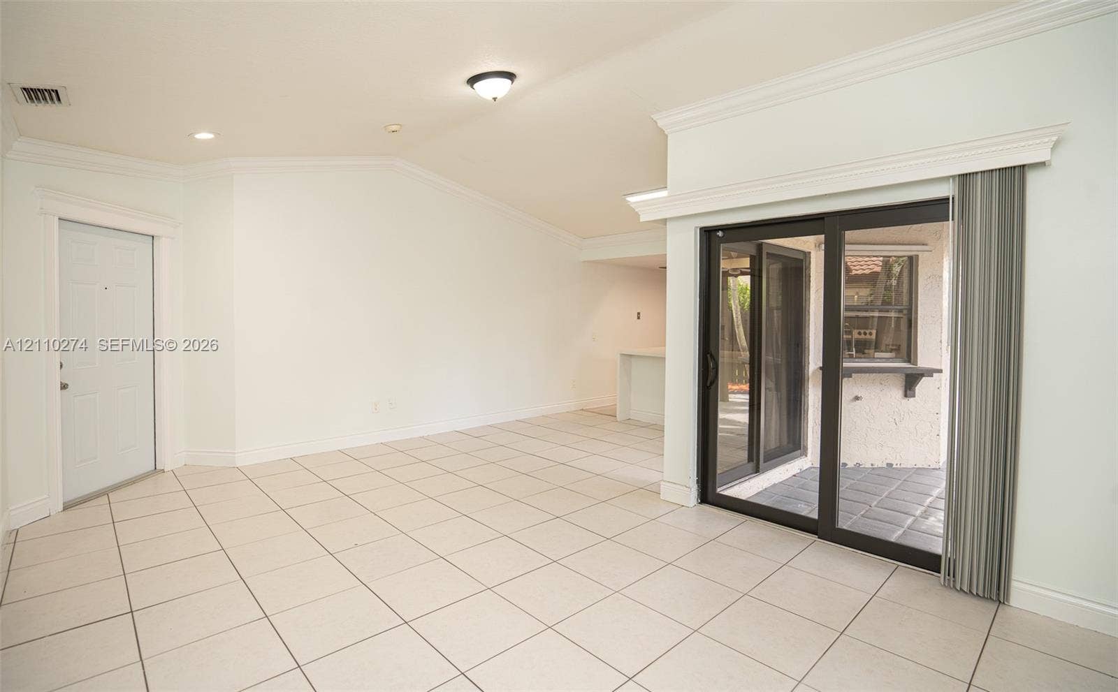 14955 SW 49th Lane, #5E, Miami, FL 33185 Vaulted ceilings, neutral tile flooring, sliding glass patio doors, crown molding, and recessed lighting