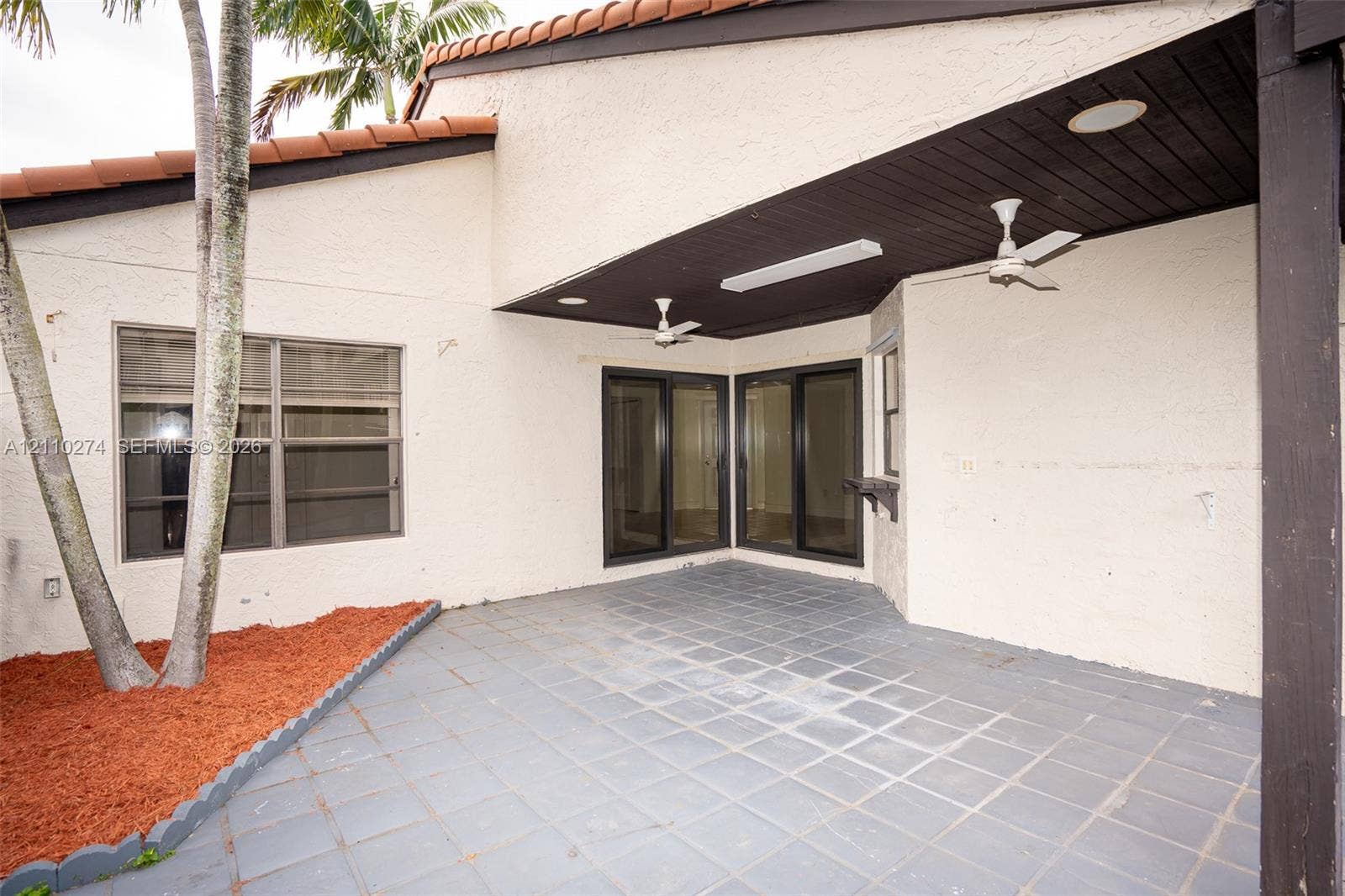 14955 SW 49th Lane, #5E, Miami, FL 33185 Covered outdoor patio featuring tiled flooring, recessed lighting, dual ceiling fans, and sliding glass doors