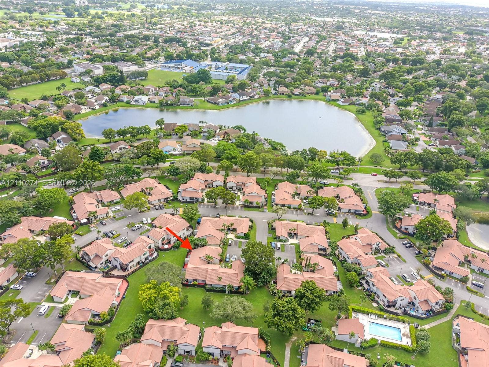 14955 SW 49th Lane, #5E, Miami, FL 33185 Aerial perspective of a multi-unit residential property featuring tile roofing, stucco exterior finishes, and established landscaping