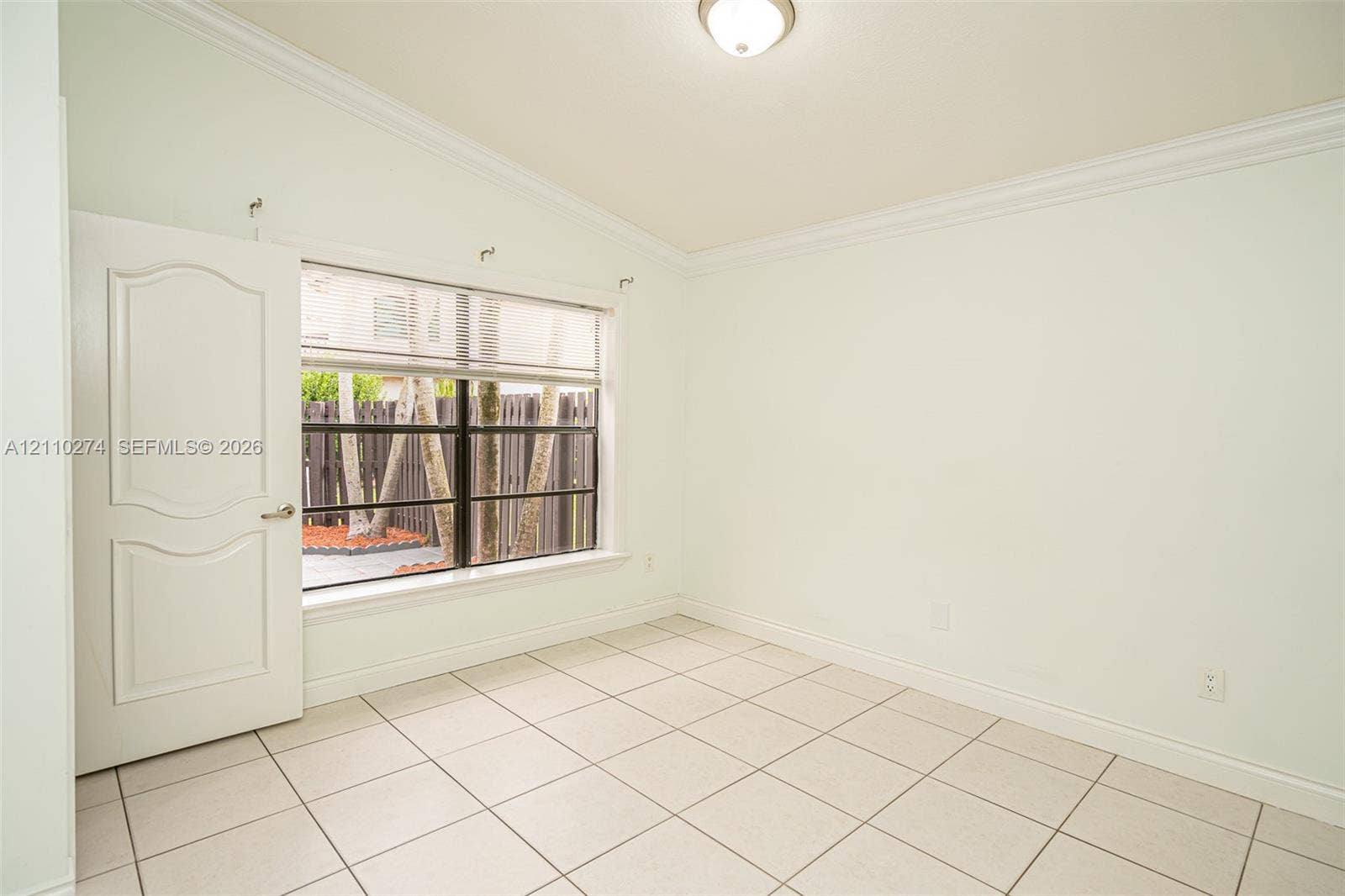 14955 SW 49th Lane, #5E, Miami, FL 33185 Room featuring vaulted ceilings, crown molding, large format tile flooring, and a multi-pane window with a black frame