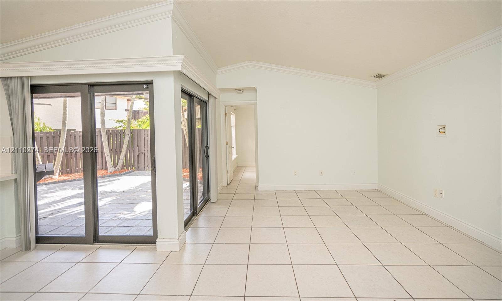14955 SW 49th Lane, #5E, Miami, FL 33185 Vaulted ceiling featuring crown molding, ceramic tile flooring, and sliding glass doors with dark frames