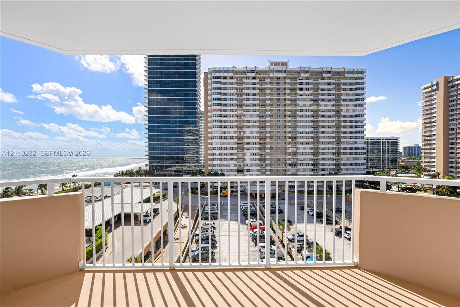 Covered balcony with white metal railings and concrete flooring