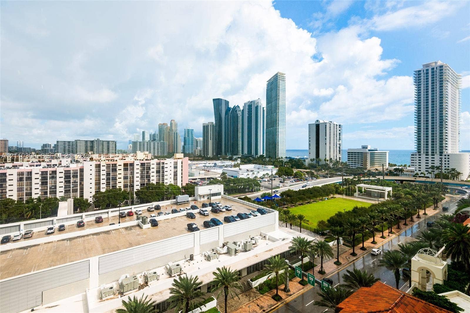 Elevated urban perspective featuring a skyline backdrop, proximity to coastline, expansive green space, and mature palm landscaping