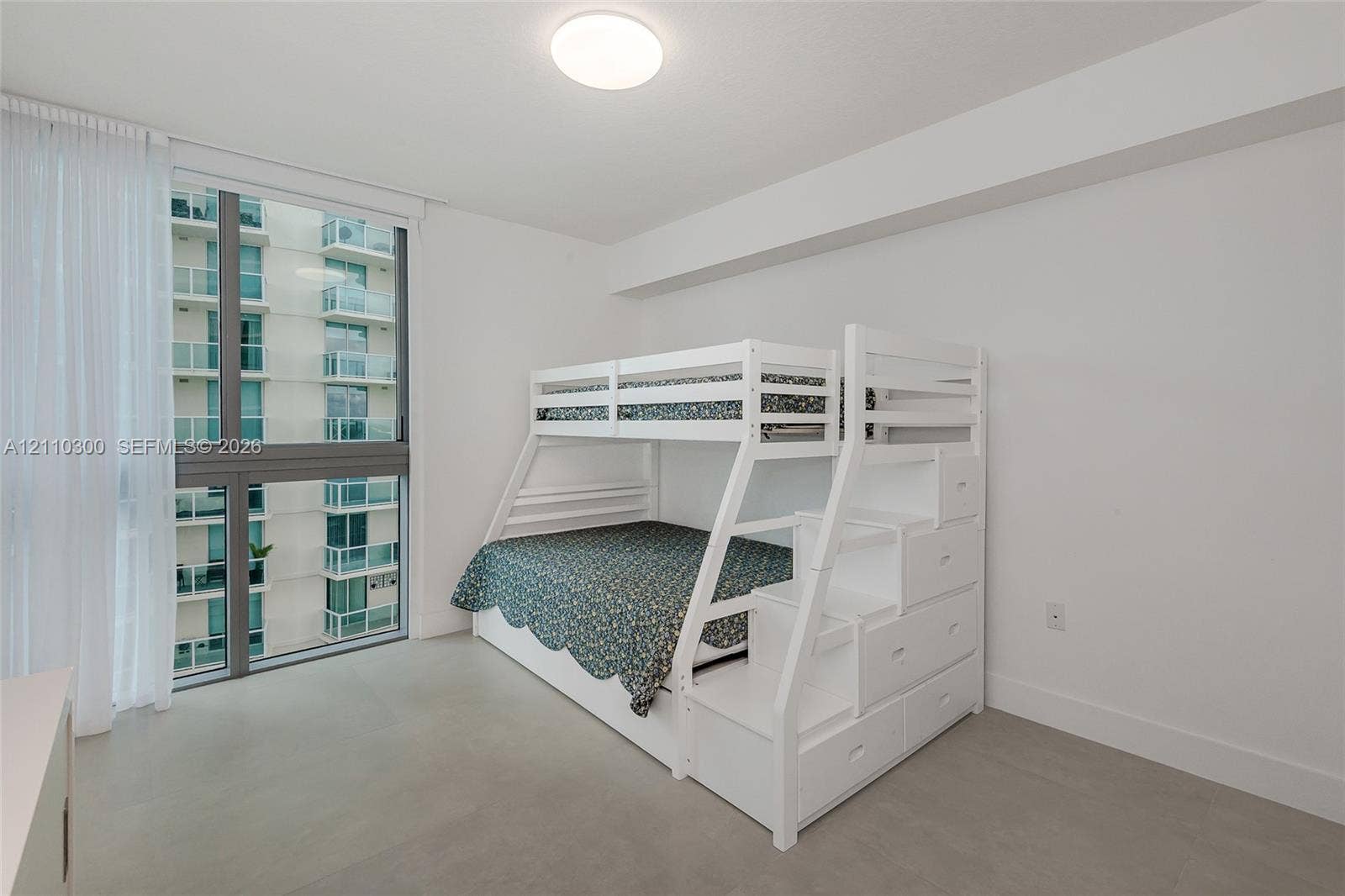 Bedroom 3. Floor-to-ceiling windows featuring metal framing, flush-mount overhead lighting, and neutral-tone flooring