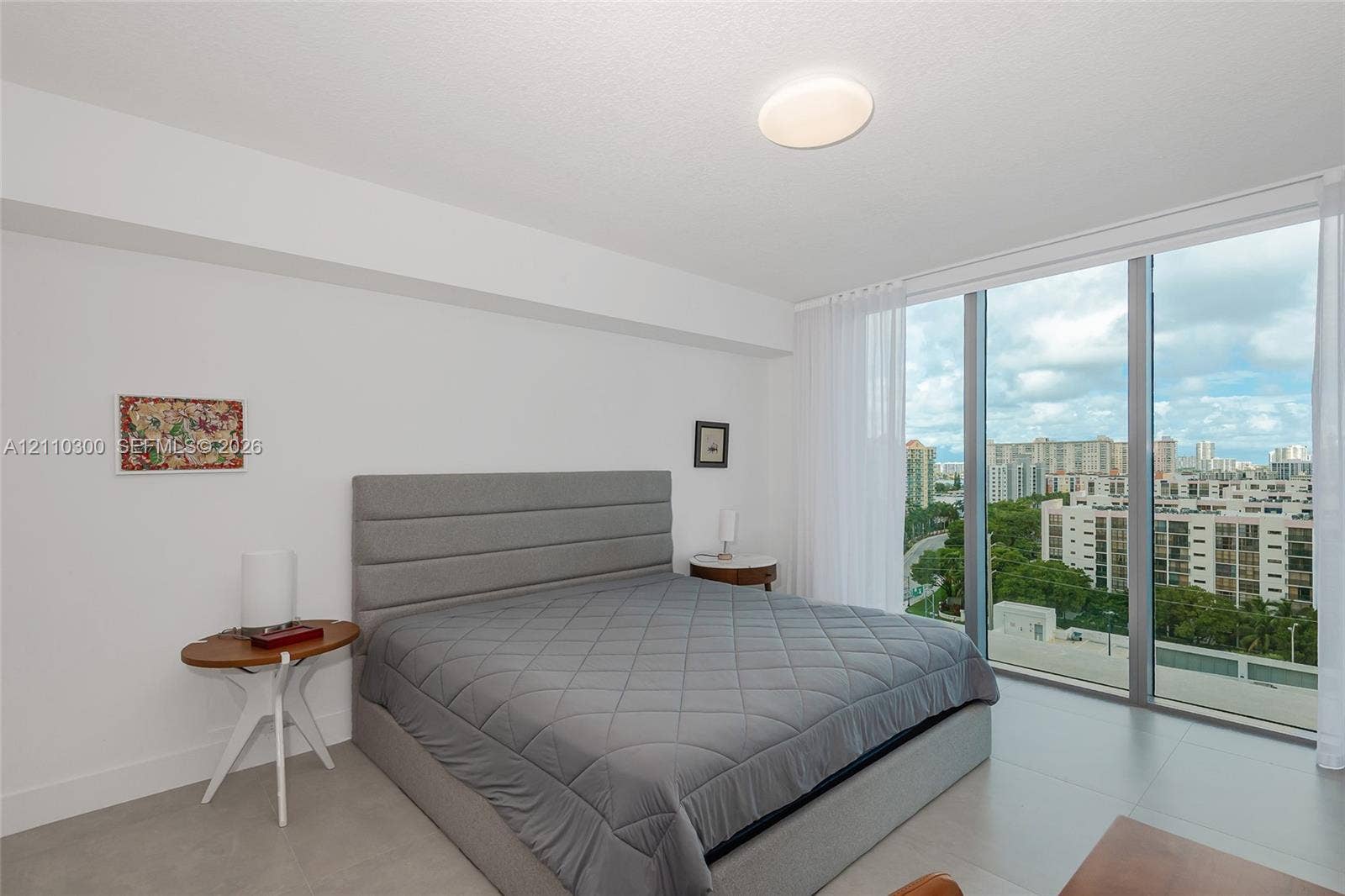 Master Bedroom. Floor-to-ceiling windows, neutral tile flooring, and flush-mount lighting
