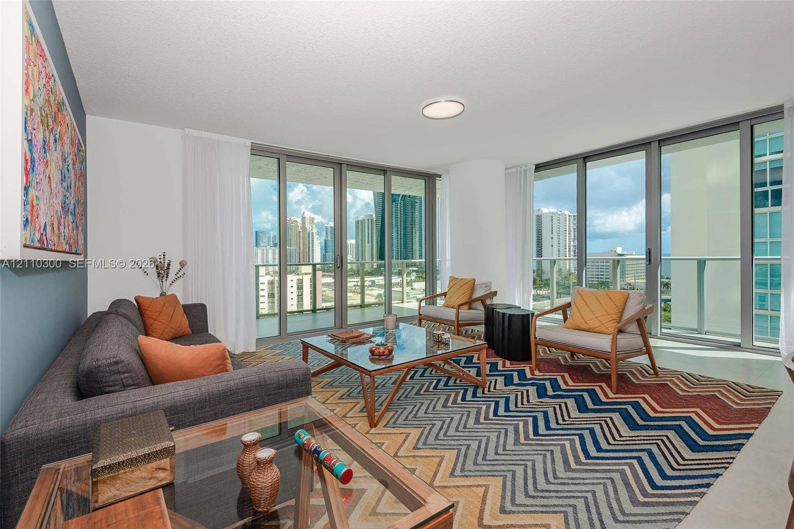 Floor-to-ceiling glass windows, wraparound balcony, neutral tile flooring, and recessed ceiling lighting
