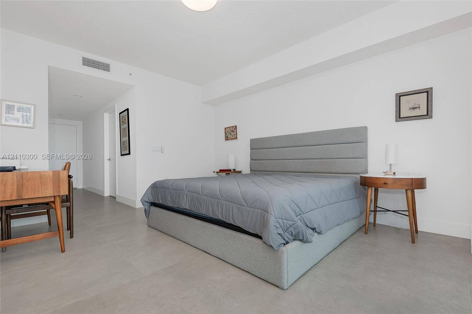 Master Bedroom. Neutral-toned large-format tile flooring, high ceilings, and recessed overhead lighting