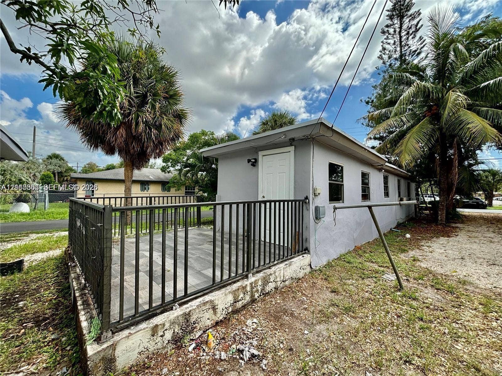729 NW 19th Avenue, Fort Lauderdale, FL 33311 Detached structure featuring a tiled patio, black metal perimeter fencing, and concrete foundation