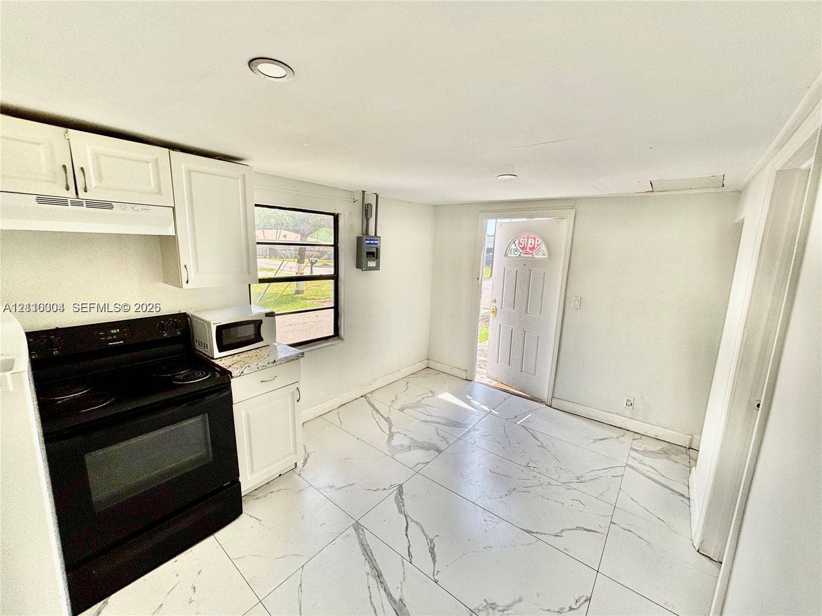729 NW 19th Avenue, Fort Lauderdale, FL 33311 Kitchen featuring white shaker-style cabinetry, a black electric range, stone-finish countertops, recessed lighting, and large-format tile flooring