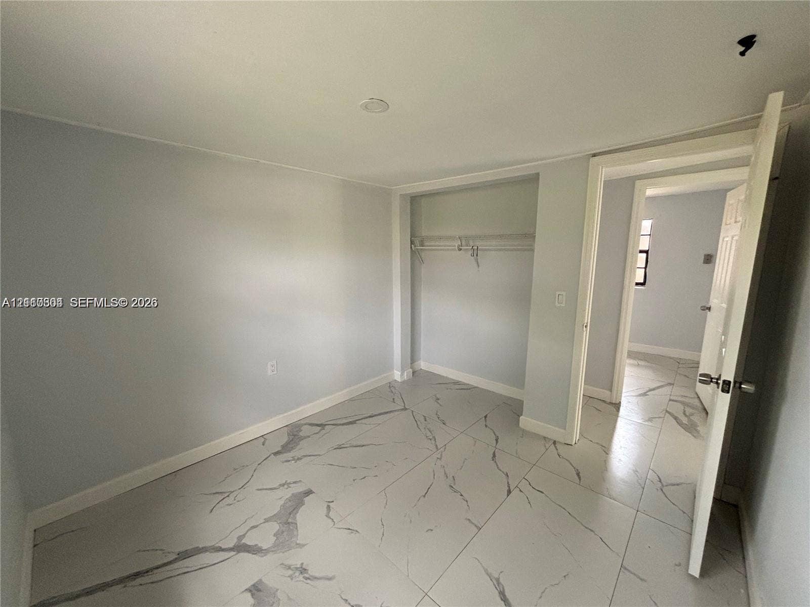 729 NW 19th Avenue, Fort Lauderdale, FL 33311 Interior room featuring large-format tile flooring with a neutral veined pattern, recessed ceiling lighting, and a built-in closet with integrated shelving