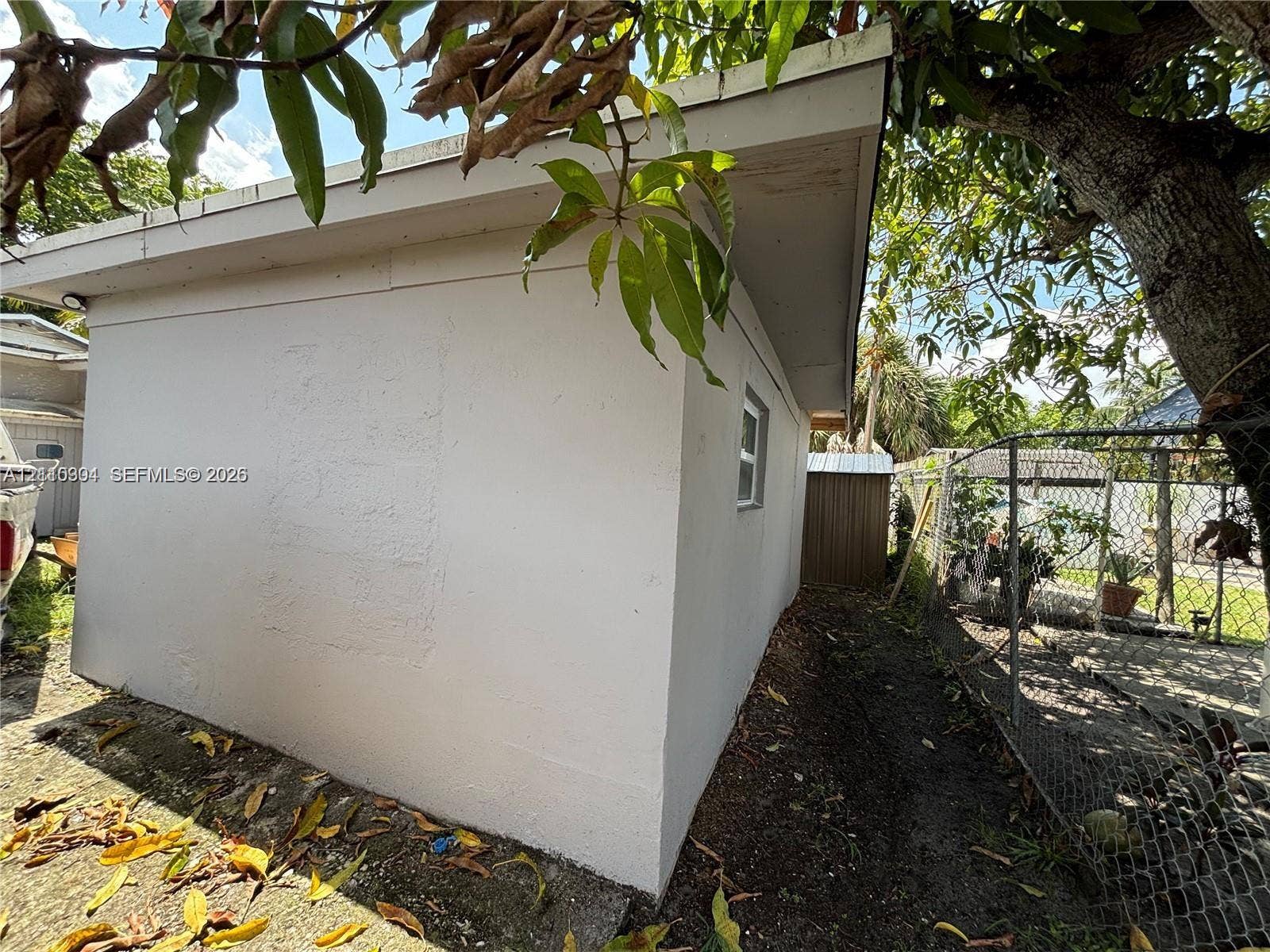 729 NW 19th Avenue, Fort Lauderdale, FL 33311 Stucco exterior with a pitched roofline and chain-link fencing
