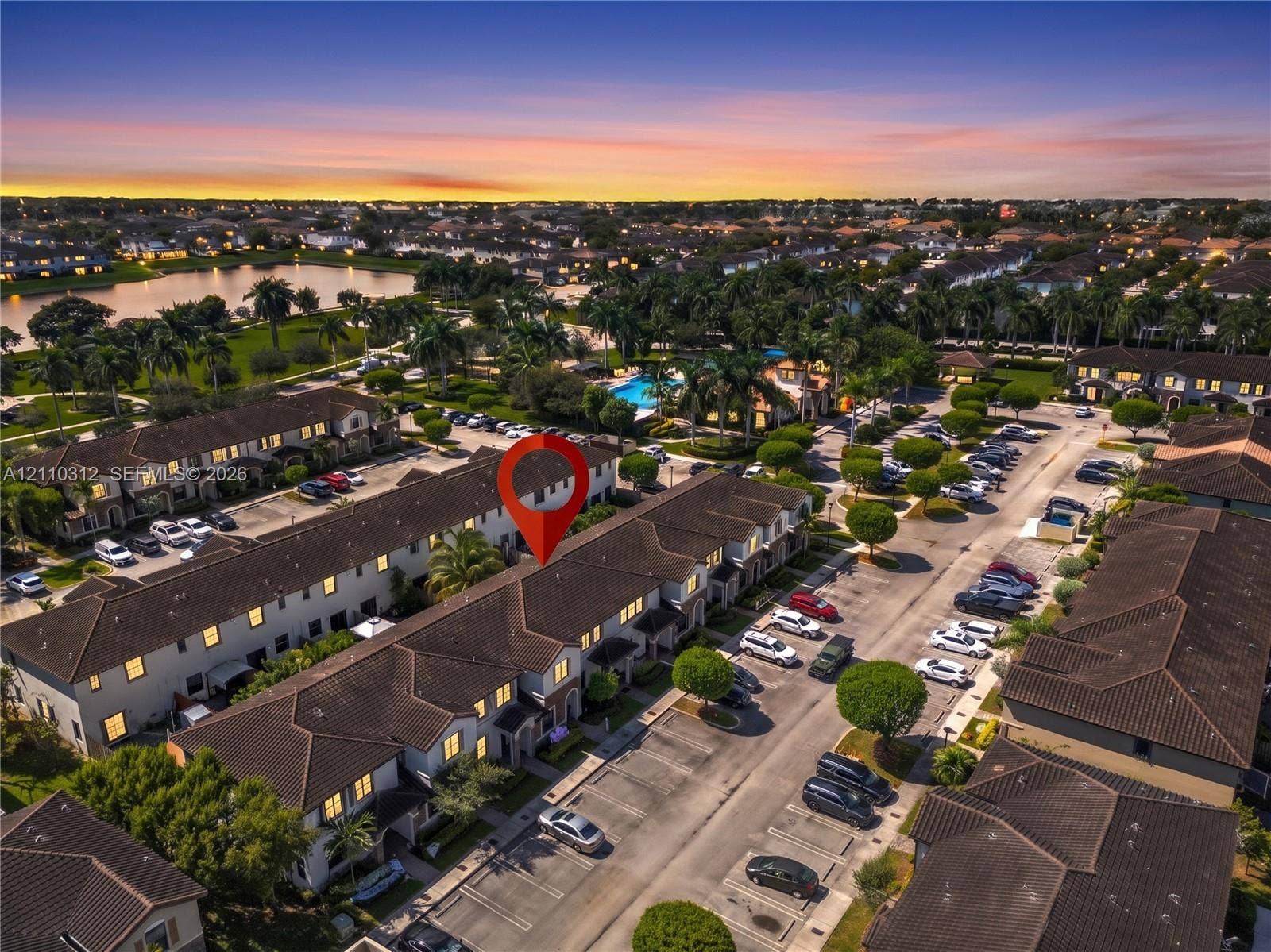 11524 SW 248th Lane, Homestead, FL 33032 Aerial perspective of multi-story townhome complex featuring a tile roof, dedicated parking spaces, and extensive landscaping