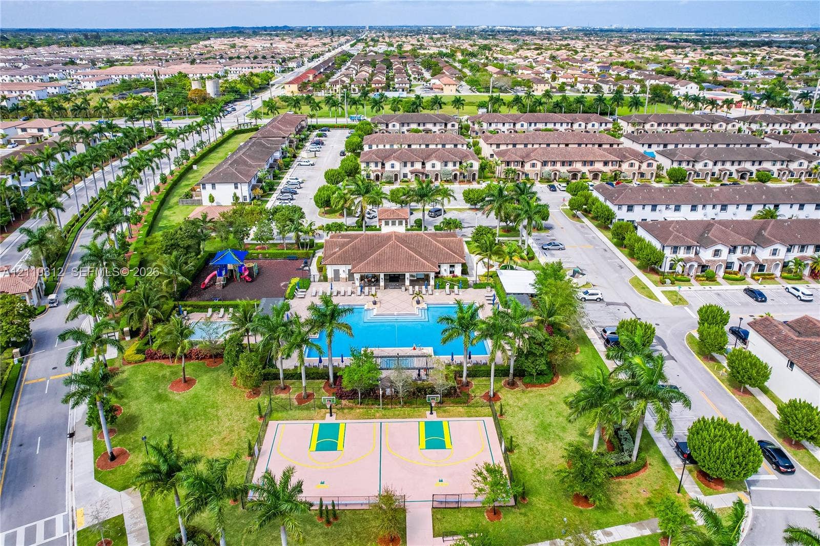 11524 SW 248th Lane, Homestead, FL 33032 Community clubhouse with an outdoor swimming pool, basketball court, playground, and manicured green spaces