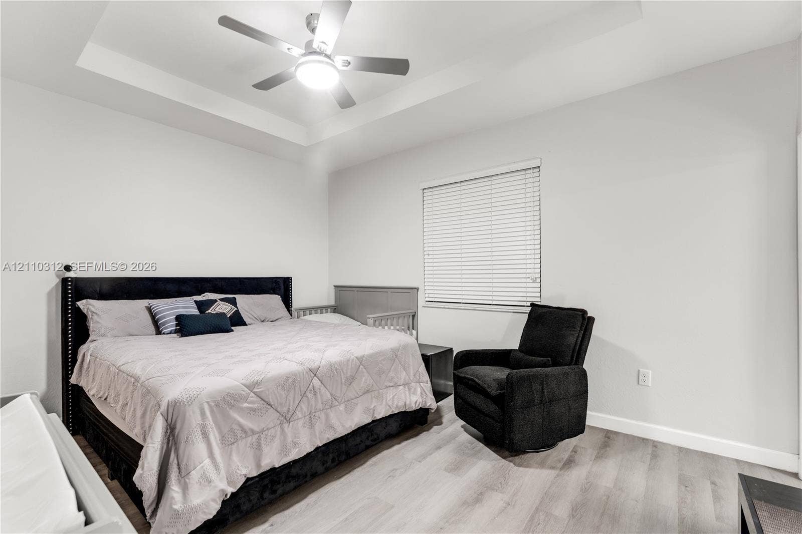 11524 SW 248th Lane, Homestead, FL 33032 Tray ceiling, multi-speed ceiling fan with integrated light fixture, wood-finish flooring, and horizontal window blinds