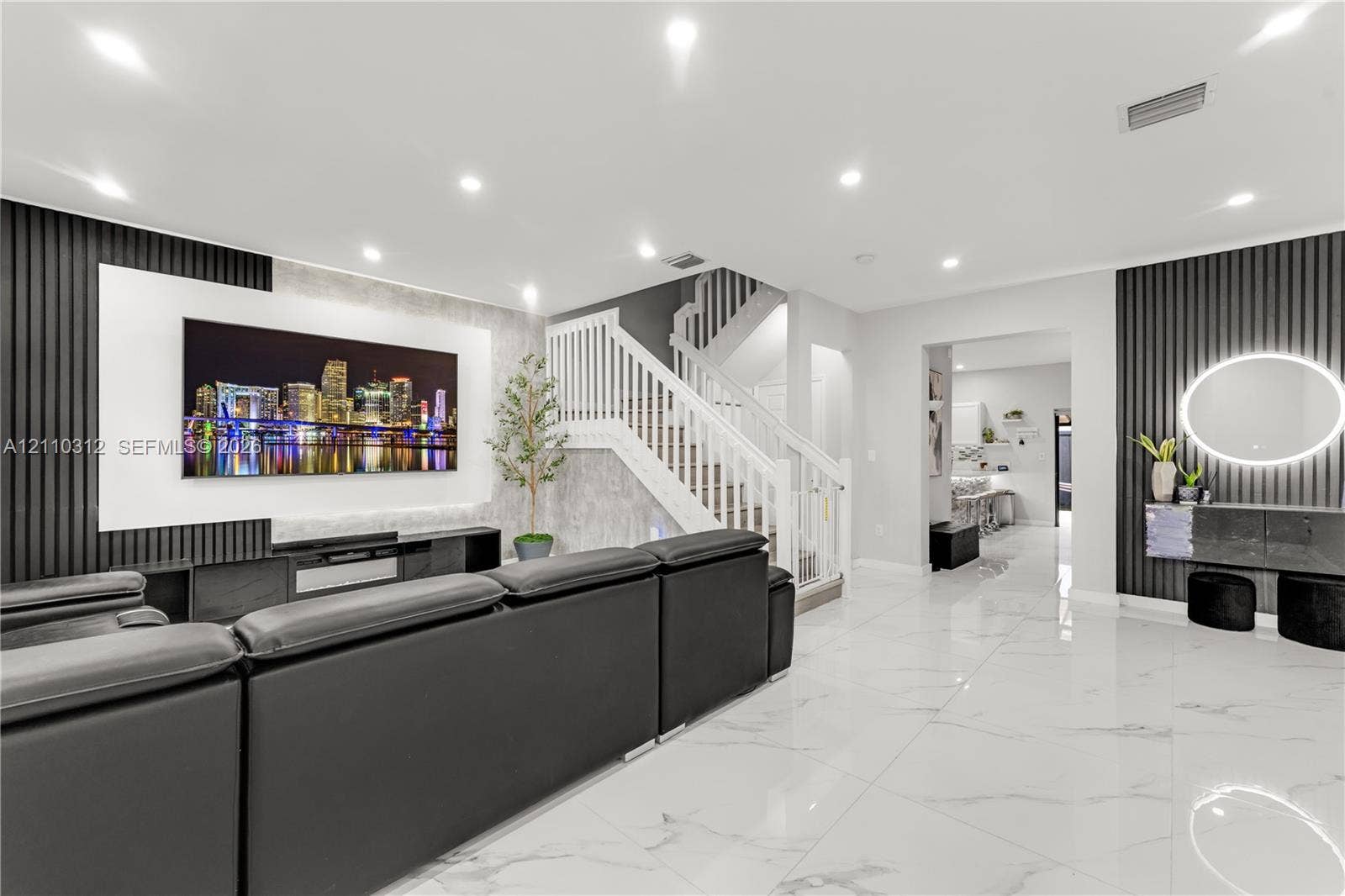 11524 SW 248th Lane, Homestead, FL 33032 Living area featuring large-format tile flooring, recessed ceiling lighting, vertical slat wall paneling, and a staircase with white wood railings
