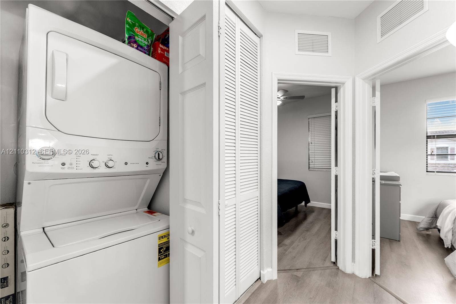 11524 SW 248th Lane, Homestead, FL 33032 Laundry area featuring a stackable white washer and dryer unit concealed by louvered bi-fold doors