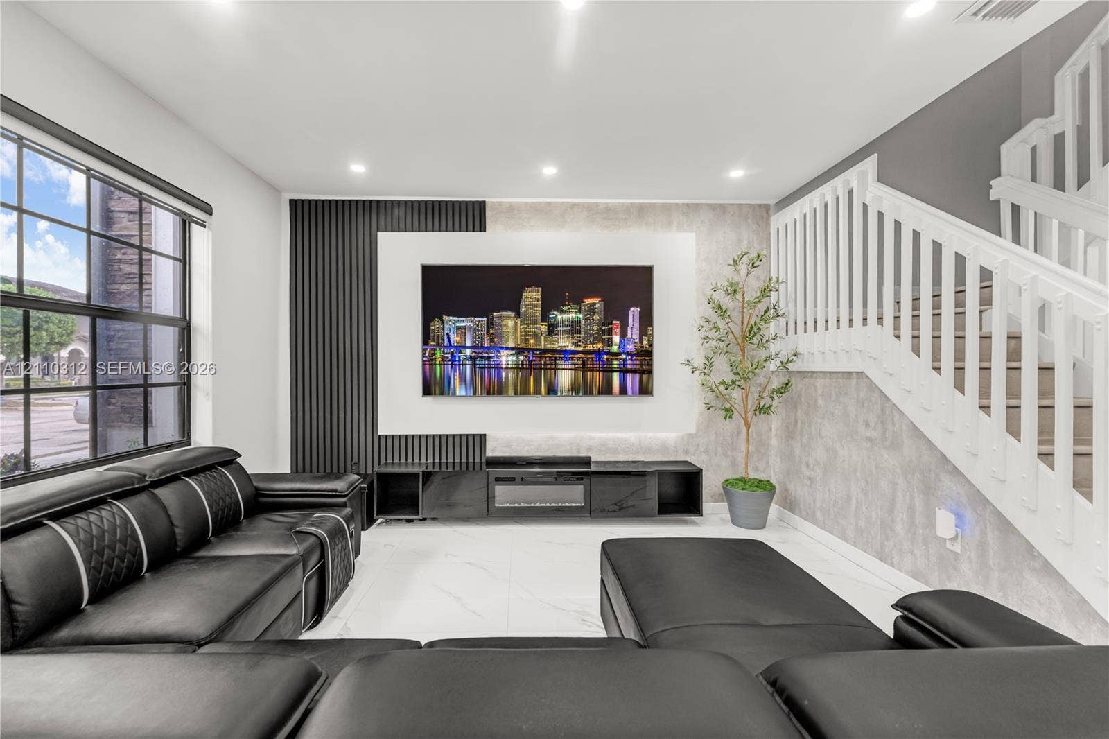 11524 SW 248th Lane, Homestead, FL 33032 Living area featuring large-format tile flooring, recessed lighting, and a focal wall with vertical slat paneling and integrated entertainment cabinetry