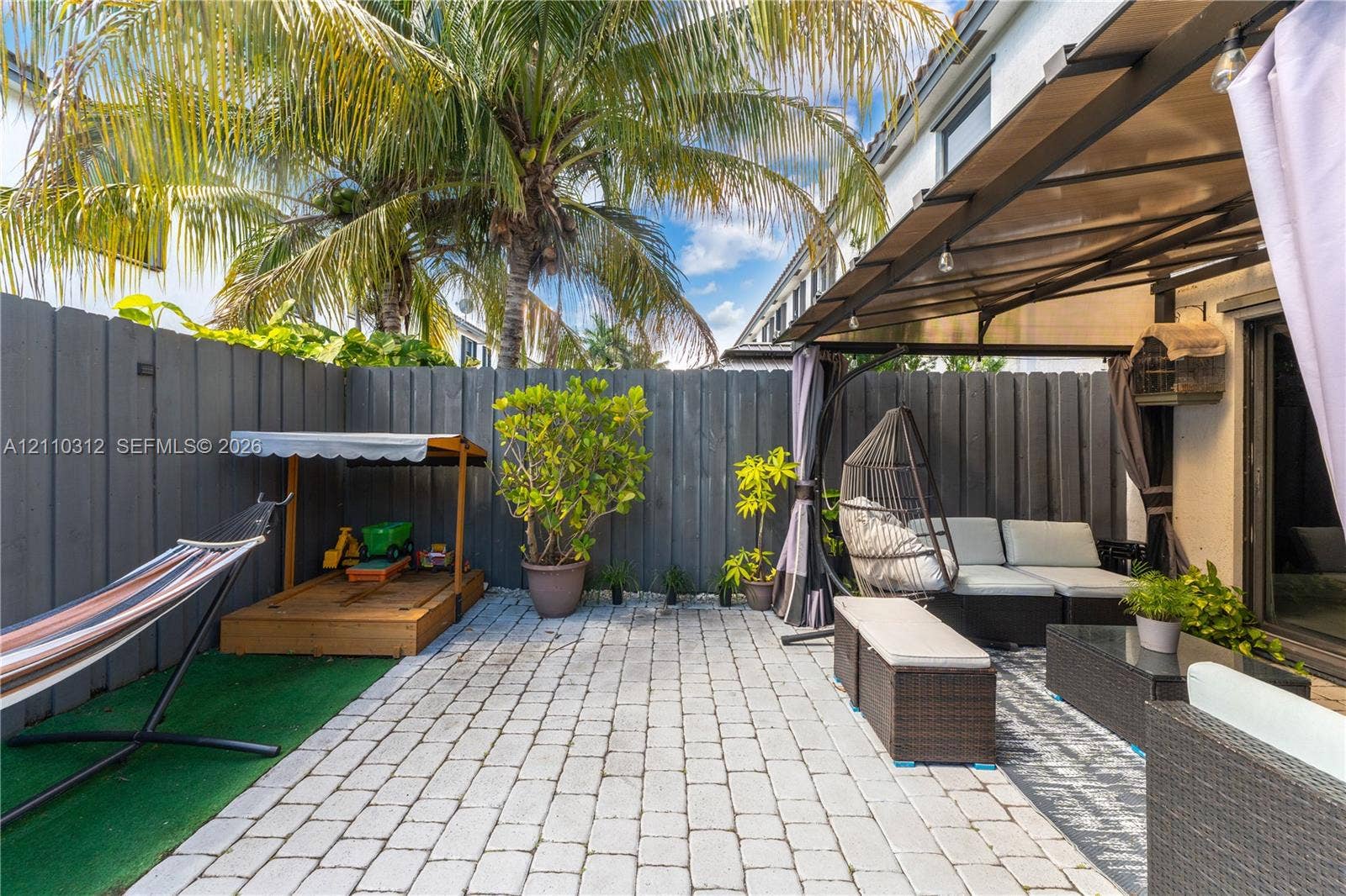 11524 SW 248th Lane, Homestead, FL 33032 Private patio featuring stone paver flooring, overhead metal-framed structure, and full-height perimeter fencing