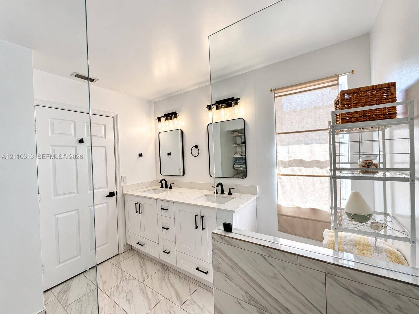 17731 SW 23rd Street, Miramar, FL 33029 Dual-sink vanity with white cabinetry, light-toned stone-finish countertops, rectangular undermount sinks, matte black fixtures, and framed mirrors