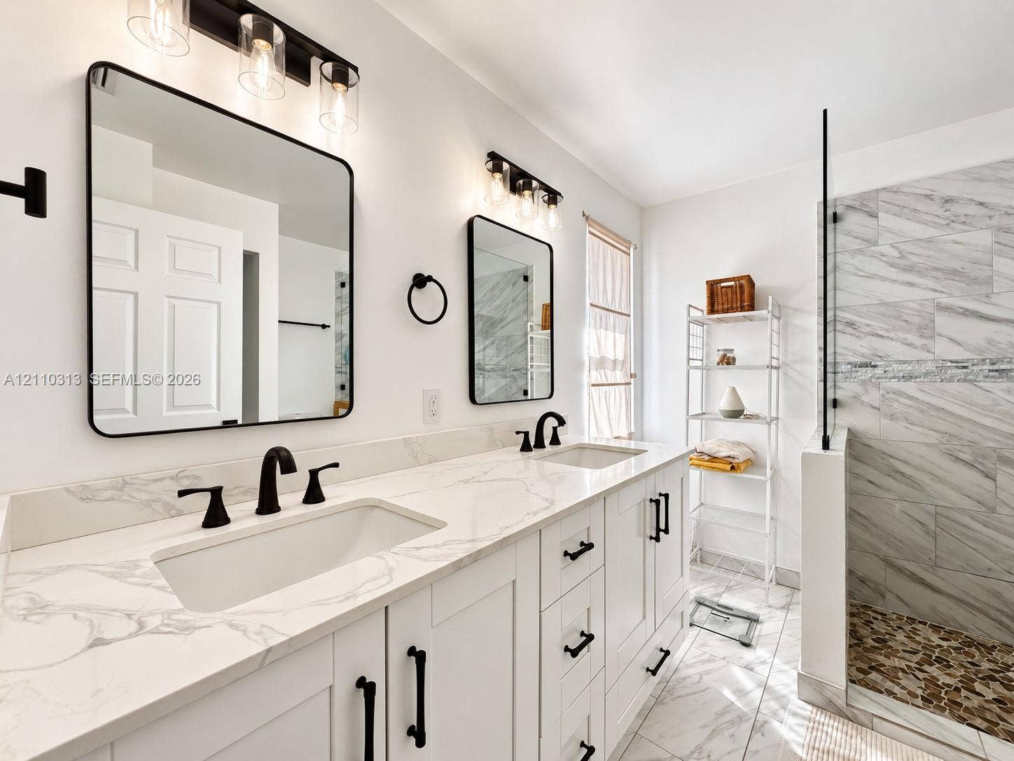 17731 SW 23rd Street, Miramar, FL 33029 Double vanity featuring white cabinetry, stone-surface countertops, under-mount rectangular sinks, and matte black hardware, accompanied by a glass-enclosed walk-in shower with tiled walls and a stone-tiled floor