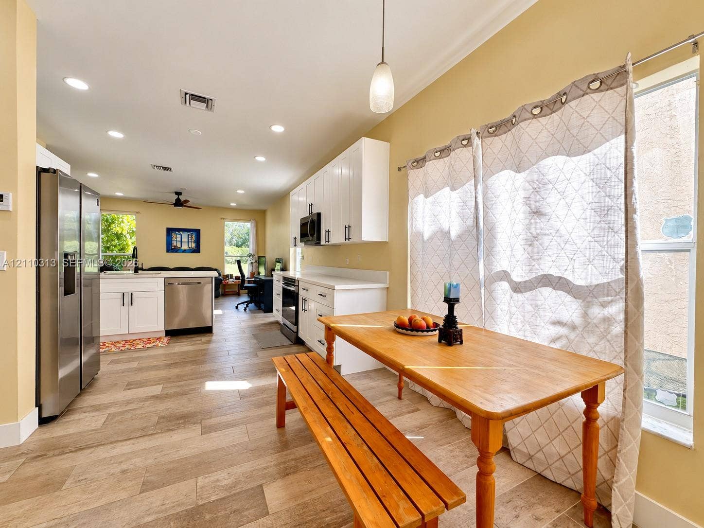17731 SW 23rd Street, Miramar, FL 33029 Kitchen featuring white shaker-style cabinetry, stainless steel appliances, wood-finish tile flooring, recessed lighting, and a pendant light fixture