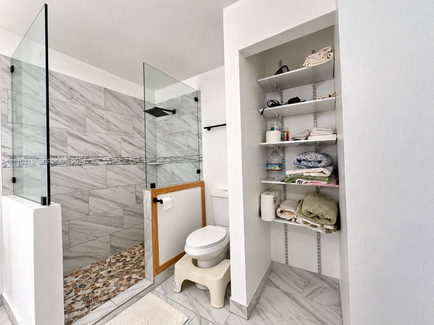 17731 SW 23rd Street, Miramar, FL 33029 Walk-in shower featuring a glass enclosure, rainfall showerhead, and multi-tone pebble flooring