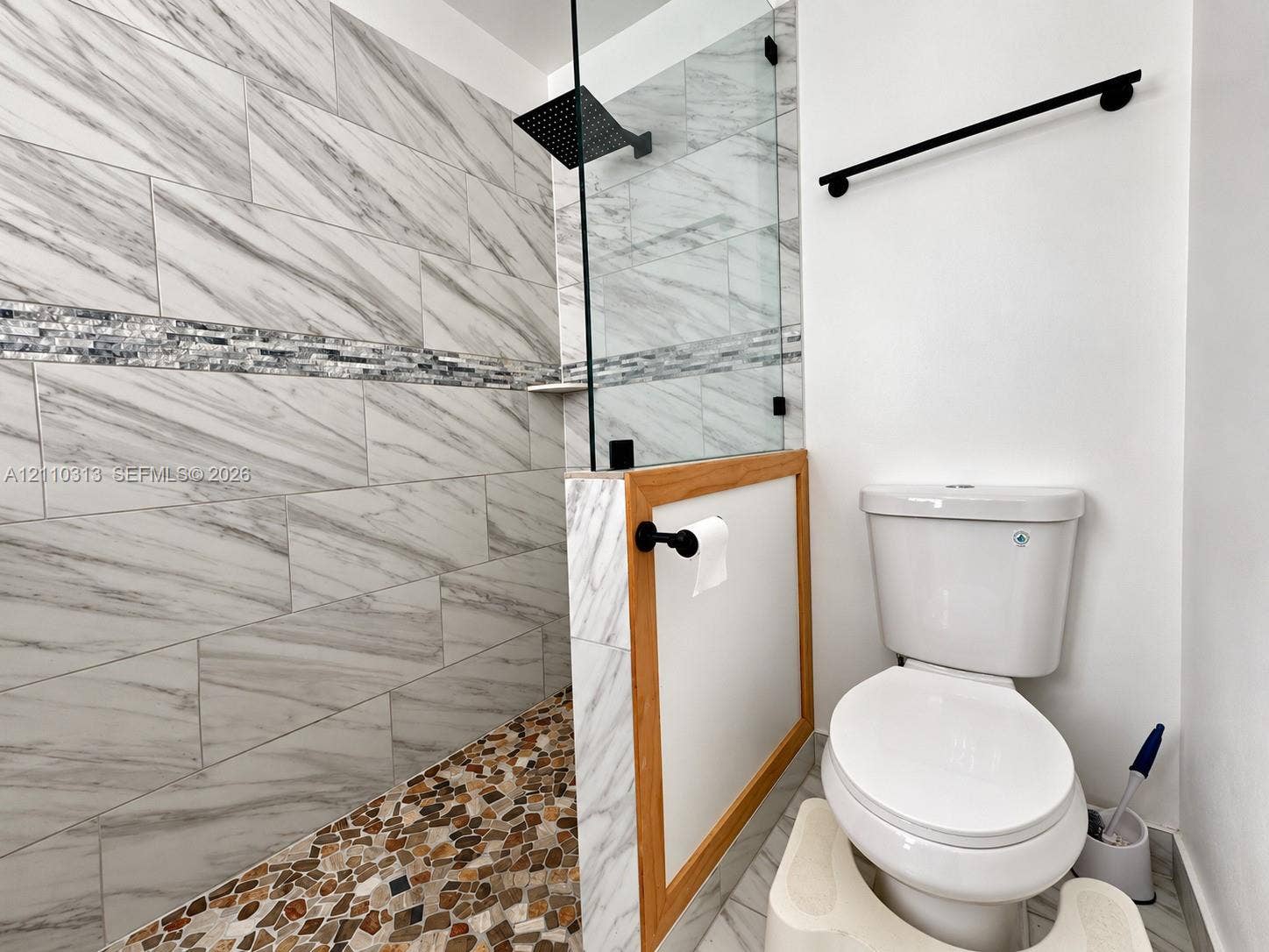 17731 SW 23rd Street, Miramar, FL 33029 Walk-in shower with stone-tiled flooring, large-format wall tile, glass enclosure, and a square matte black shower head