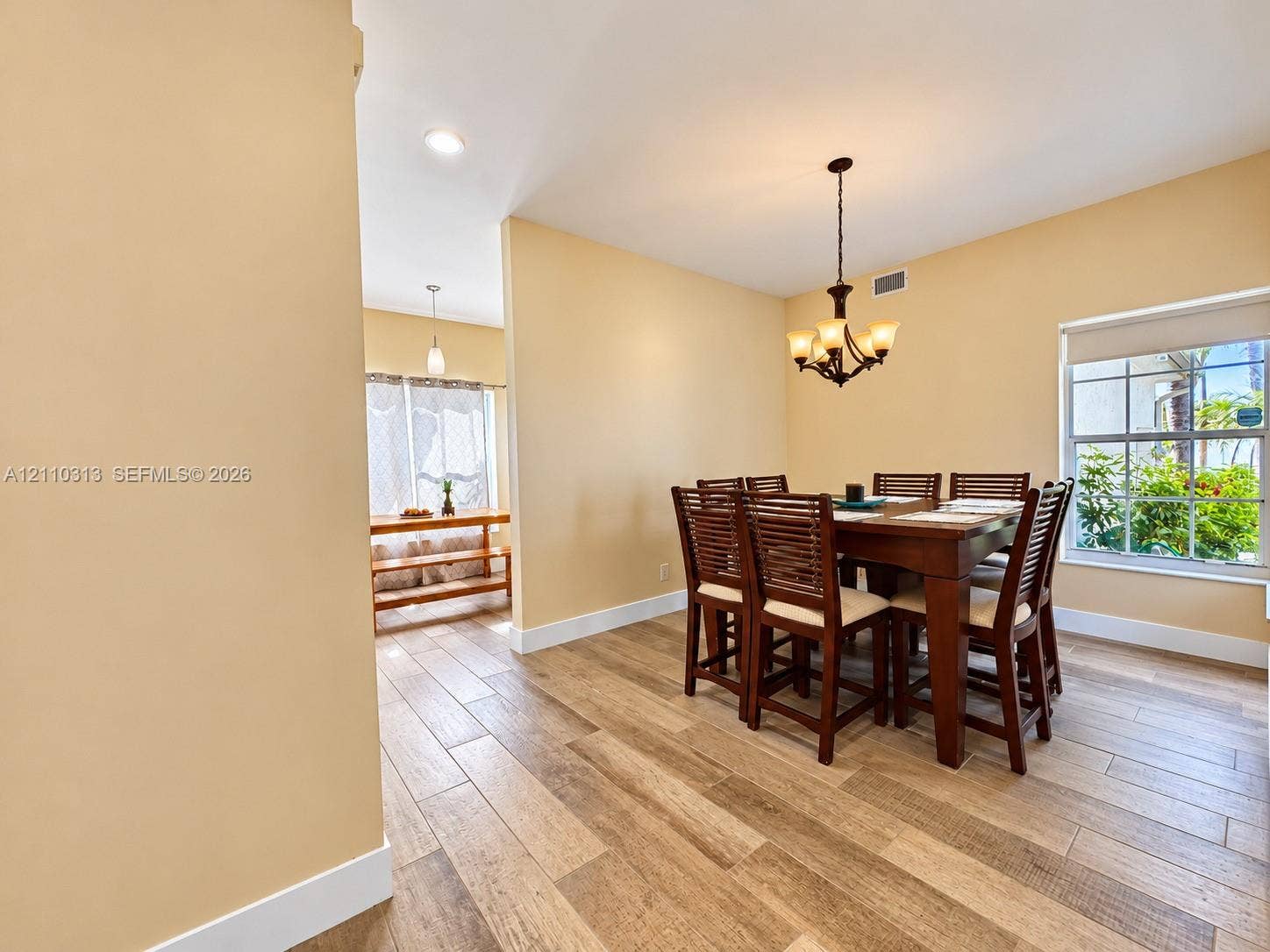 17731 SW 23rd Street, Miramar, FL 33029 Wood-finish tile flooring, multi-pane windows, and a multi-light hanging chandelier