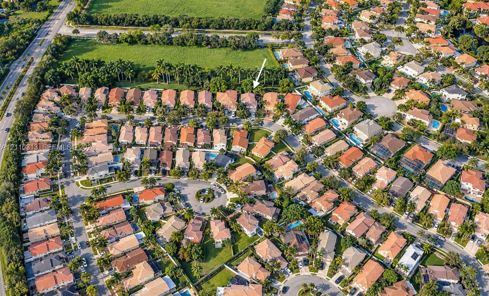 17731 SW 23rd Street, Miramar, FL 33029 Aerial perspective of a residential community featuring tile-roofed architecture, paved street grids, landscaped green spaces, and dense perimeter foliage