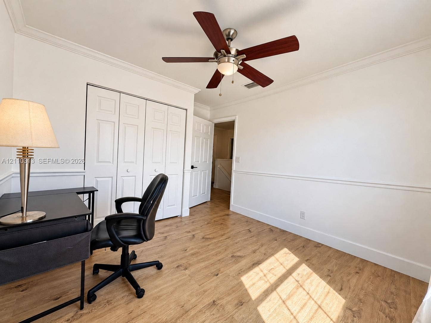 17731 SW 23rd Street, Miramar, FL 33029 Room featuring wood-finish flooring, crown molding, chair rail molding, a multi-panel closet door, and a ceiling fan with integrated lighting