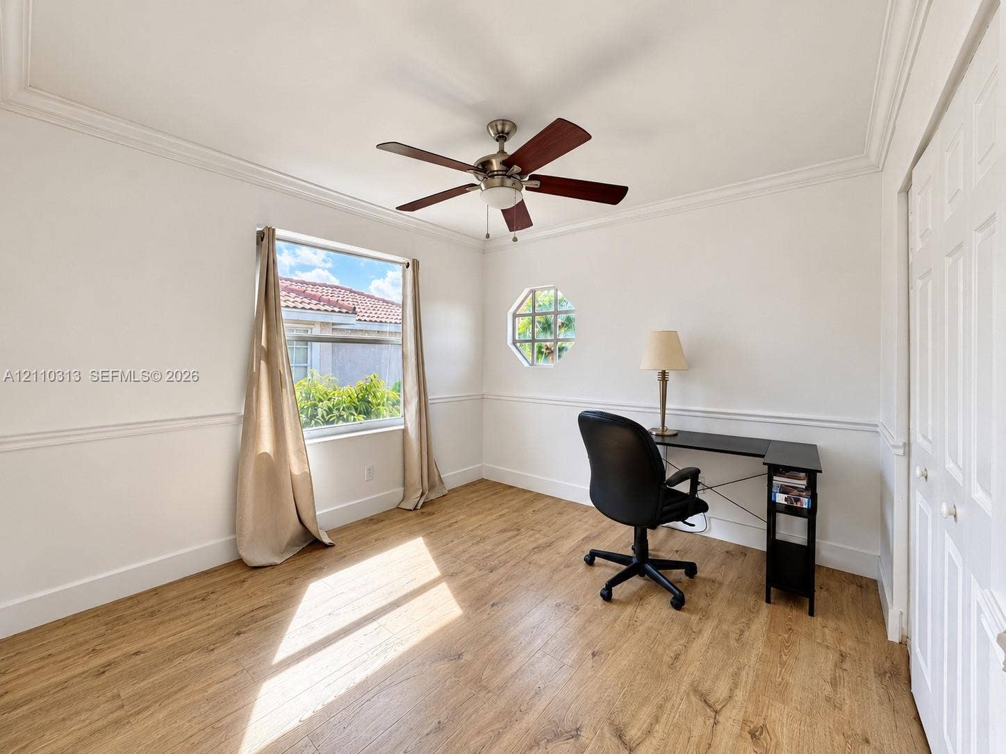 17731 SW 23rd Street, Miramar, FL 33029 Room featuring wood-finish flooring, crown molding, chair rail trim, an octagonal window, and a ceiling fan with integrated light fixture