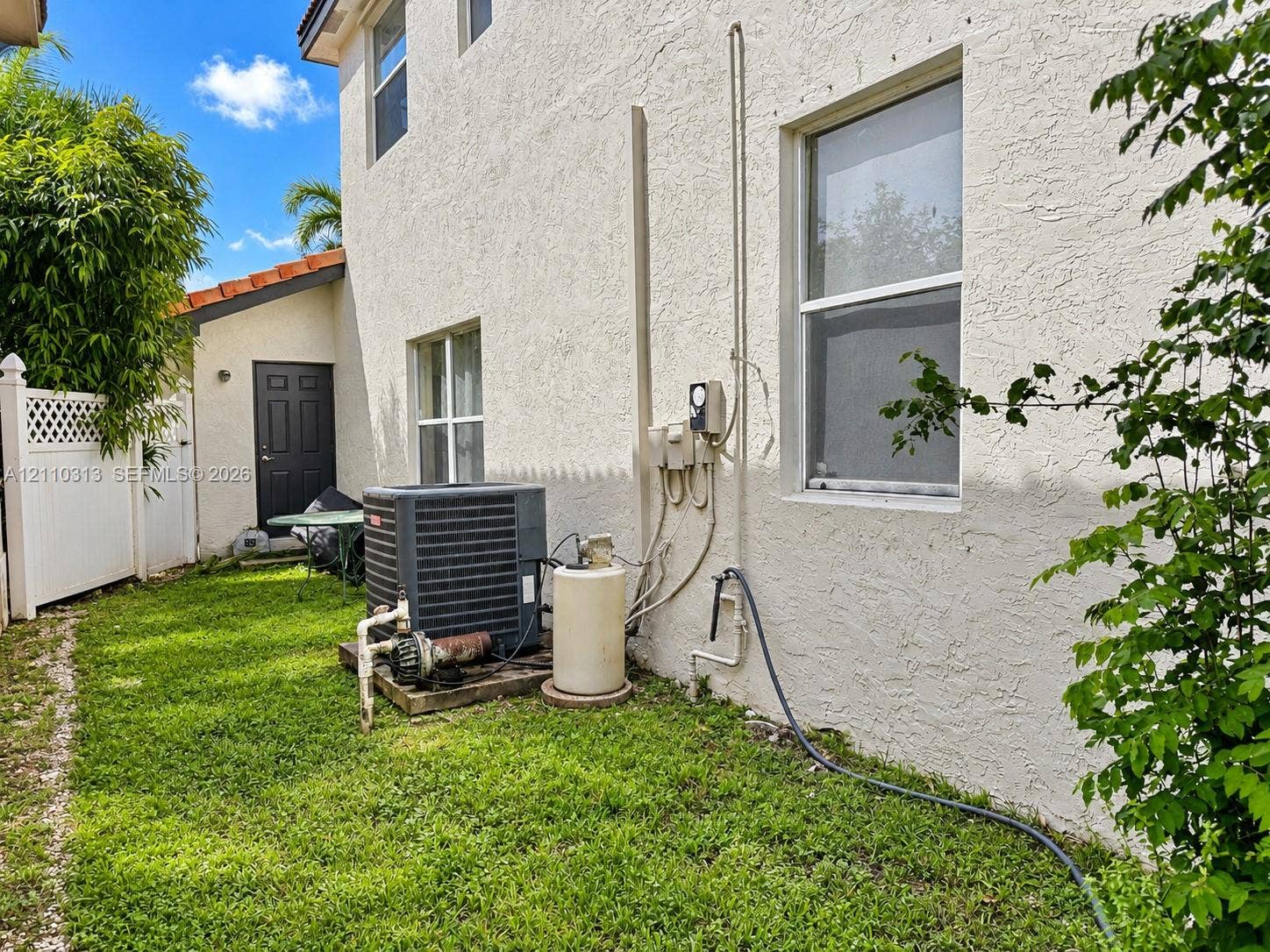 17731 SW 23rd Street, Miramar, FL 33029 Stucco exterior featuring dual-pane windows, a tiled roofline, and white vinyl privacy fencing